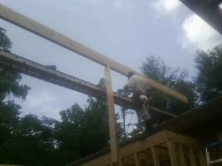 Carpenter setting a ridge beam over a new addition frame — Ice Dam Removal by Roofing Brothers in Ruthton