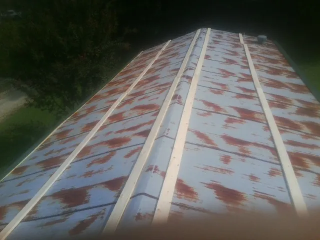 Rusted metal roof panels with new wood purlins before replacement — Storm Damage Roof Repair in Ruthton by Roofing Brothers