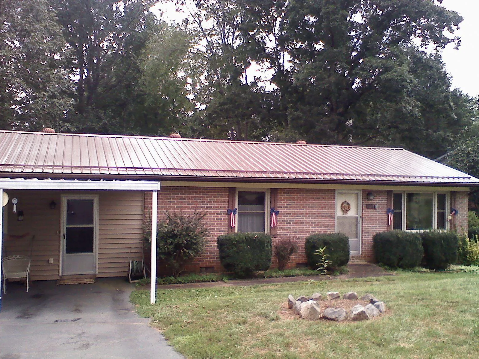 Bronze metal roof and carport on a brick ranch home — Roof Repair work by our crew in Ruthton